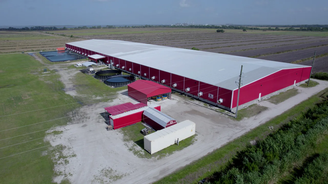 Aerial view of an aquaculture building and adjacent tanks